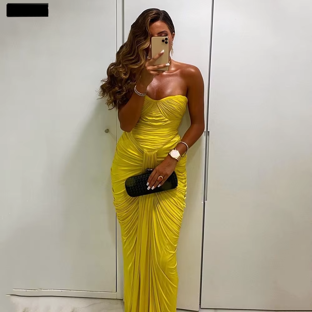A model wearing a yellow strapless, long, chiffon, mermaid silhouette dress with a sweetheart neckline.